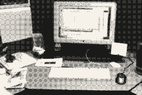 Planilla abierta en un monitor de tubo, en un cubículo de oficina.
