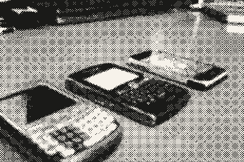 Tres teléfonos móviles de 2008, con teclado, sobre un escritorio de madera.